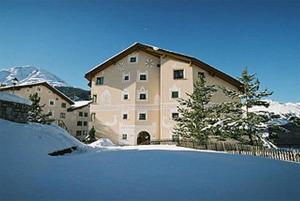a large building with snow in front of it at Chesa Delfin in Pontresina
