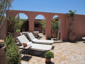 een patio met 2 ligstoelen en een tafel bij Riad Zen House in Marrakesh