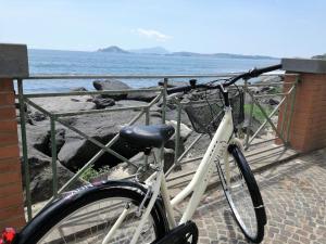 a white bike parked next to a fence near the ocean at Hotel Nuvò in Naples