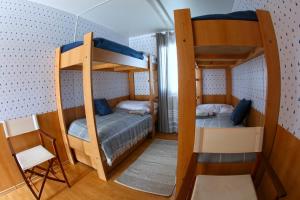 two bunk beds in a small room with a chair at YACHTER CLUB Modrá Čajka in Dunacsún
