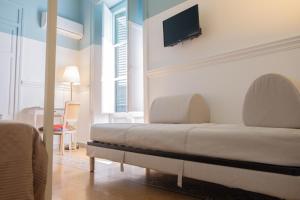 a bedroom with a bed and a tv on the wall at Al teatro Massimo in Palermo