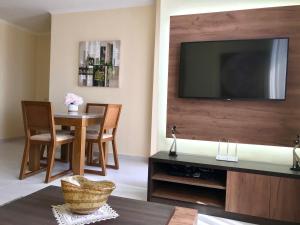 ein Wohnzimmer mit einem Tisch und einem TV an der Wand in der Unterkunft EKA Luxury Penthouse in Durrës