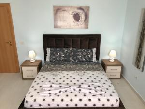 a bedroom with a large bed with two night stands at EKA Luxury Penthouse in Durrës