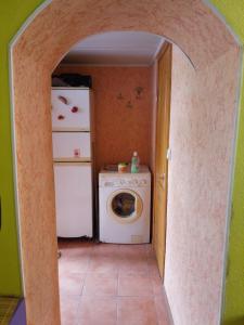 a laundry room with a refrigerator and a washing machine at Домик у моря in Odesa