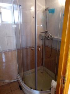 y baño con ducha y puerta de cristal. en Домик у моря en Odesa