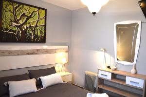 sypialnia z łóżkiem i obrazem na ścianie w obiekcie Apartamento El Mirador de Cadiz w Kadyksie