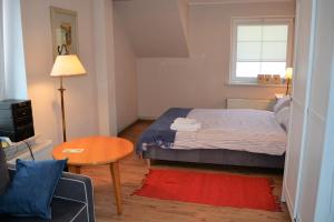 a small bedroom with a bed and a table at Apartament Margarita in Mrągowo
