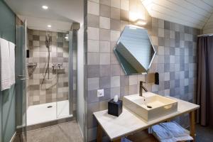 uma casa de banho com um lavatório, um chuveiro e um espelho. em Hotel Münzgasse - Self Check-in em Lucerna