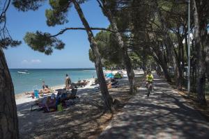 eine Person, die am Strand Fahrrad fährt in der Unterkunft Holiday Centre Bi village in Fažana