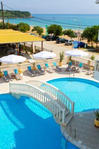 una gran piscina con sillas y sombrillas en Vrachos Beach Hotel en Vrachos