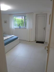 ein weißes Zimmer mit einem Bett und einem Fenster in der Unterkunft New "Casa Maria" in Ascona