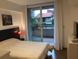 a bedroom with a bed and a sliding glass door at Departamento moderno in Rosario