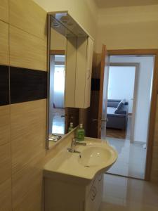 a bathroom with a sink and a mirror and a couch at Apartman Lucija in Zadar