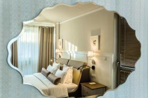 een slaapkamer met een grote spiegel boven een bed bij Hotel Residence Promenade in Boergas