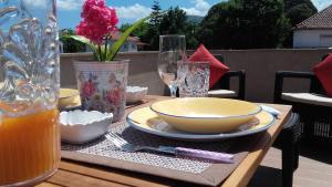 een houten tafel met een kom en borden en glazen bij Apartamento Avenida in Ponte de Lima