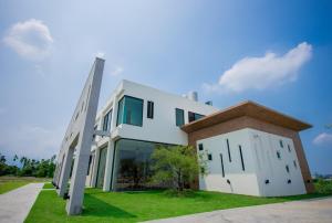 a white building with a cross on the grass at Here Homestay in Zhongpu