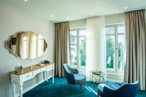 a hotel room with a vanity and chairs and a mirror at Hotel Residence Promenade in Burgas City