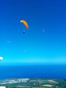 a kite flying in the sky over the ocean at Les bungalows de la kazouale in Saint-Leu