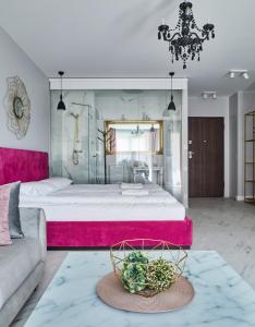 um quarto com uma cama grande e uma cabeceira rosa em Staywin Aura Gdańsk II em Gdansk