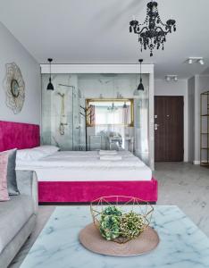 1 dormitorio con 1 cama grande y cabecero rosa en Staywin Aura Gdańsk II, en Gdansk