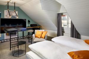 a attic bedroom with two beds and a tv at Hotel Münzgasse - Self Check-in in Luzern