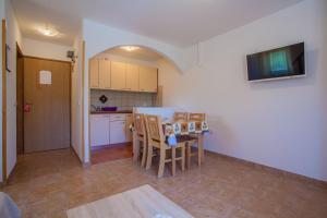 a kitchen and dining room with a table and chairs at Apartments Dandić in Orlec