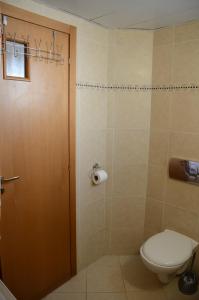 a bathroom with a toilet and a wooden door at Michelle`s Apartment in Eilat