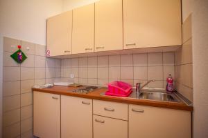 a kitchen with white cabinets and a sink at Apartments Dandić in Orlec