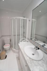 ネルハにあるCAPISTRANO PLAYA 512 MENYBERのバスルーム(洗面台、トイレ、鏡付)