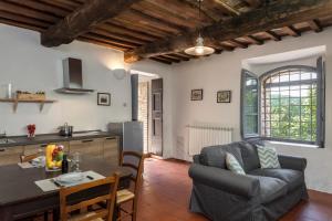 a kitchen and a living room with a couch and a table at Tenuta della Selva in Murlo
