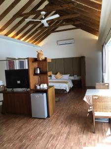 1 dormitorio con 1 cama y TV en una habitación en Shanze Bora villa, en Liugui