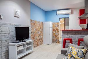 ein Wohnzimmer mit einem TV und einer Küche in der Unterkunft Apartamento Maribel in Cádiz