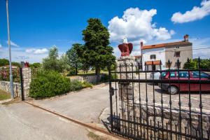 a gate with a statue of a bird on it at Apartments Dandić in Orlec