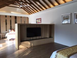 a living room with a flat screen tv on a wall at Shanze Bora villa in Liugui