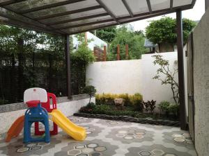 un patio trasero con un parque infantil con un tobogán en Shanze Bora villa, en Liugui