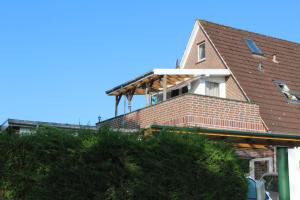 ein Haus mit einer Terrasse darüber in der Unterkunft Ferienwohnung Rabenstein in Dornum