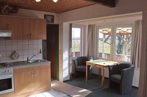 ドルヌムにあるFerienwohnung Rabensteinのテーブルと椅子のあるキッチンとダイニングルーム