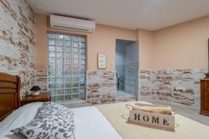 um quarto com uma cama e uma parede de tijolos em Apartamento Maribel em Cádis