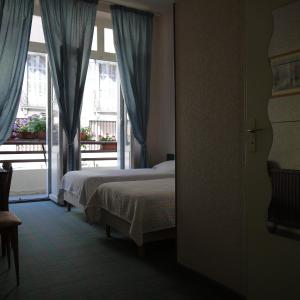 ルルドにあるHôtel Saint-Charlesのベッド2台と窓が備わるホテルルームです。