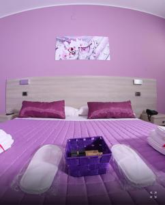 Dormitorio púrpura con cama grande con manta morada en Policlinico Happy Home, en Messina