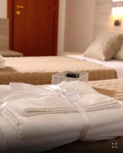 two beds with white towels on top of them at Policlinico Happy Home in Messina