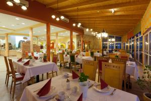 um restaurante com mesas e cadeiras com toalha de mesa branca em Thermenhotel PuchasPLUS Stegersbach em Stegersbach