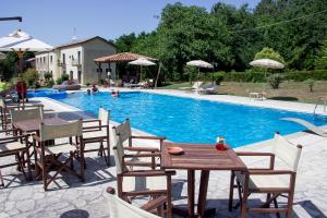 a swimming pool with a table and chairs and a table and a table at La Rosa Nel Bicchiere in Soveria Mannelli