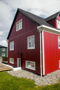 a red house with white windows on the side of it at Grundarfjördur Hostel in Grundarfjordur