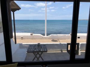 プラヤ・オンダにあるApartamento Frente al Marのベンチ付きの窓から海の景色を望めます。