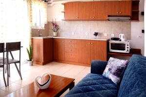 a living room with a blue couch and a kitchen at Sky-Line Apartments in Afantou