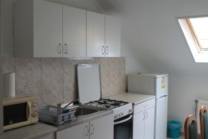 a kitchen with a sink and a stove and a refrigerator at Király Szálló & Panzió in Nagykanizsa