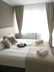 ウニエシチェにあるWilla Nestのベッドルーム1室(ベッド2台、タオル付)、窓が備わります。