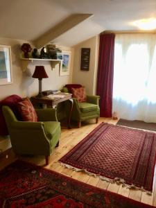 a living room with two chairs and a table and a rug at Culloden Farmhouse in Camelford