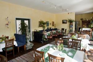 - un restaurant avec des tables et des chaises dans une salle dans l'établissement Hotel Henry, à Erding